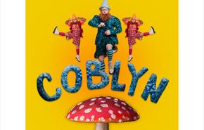 Three mischievous gnomes dancing on top of a toadstool